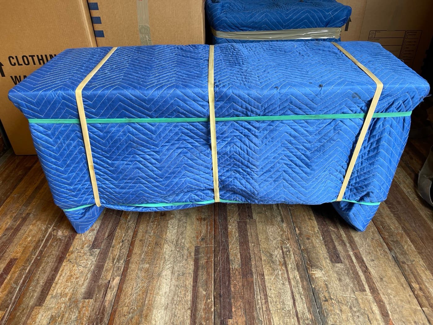 Specialty furniture wrapped in protective moving pads with banding for safe transport