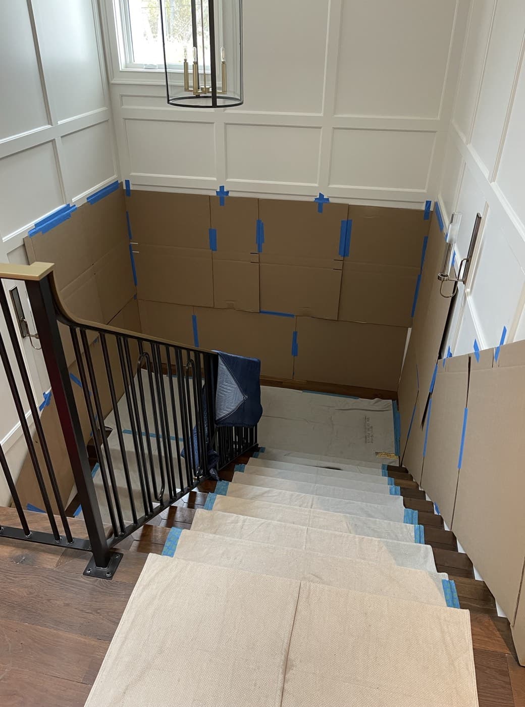 Professional packing prep with floor runners, blue tape protection, and wrapped furniture in a Bay Area home