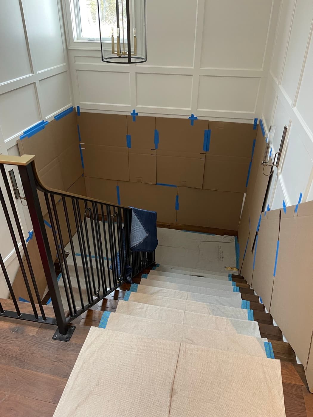 Professional packing prep with floor runners, blue tape protection, and wrapped furniture in a Bay Area home