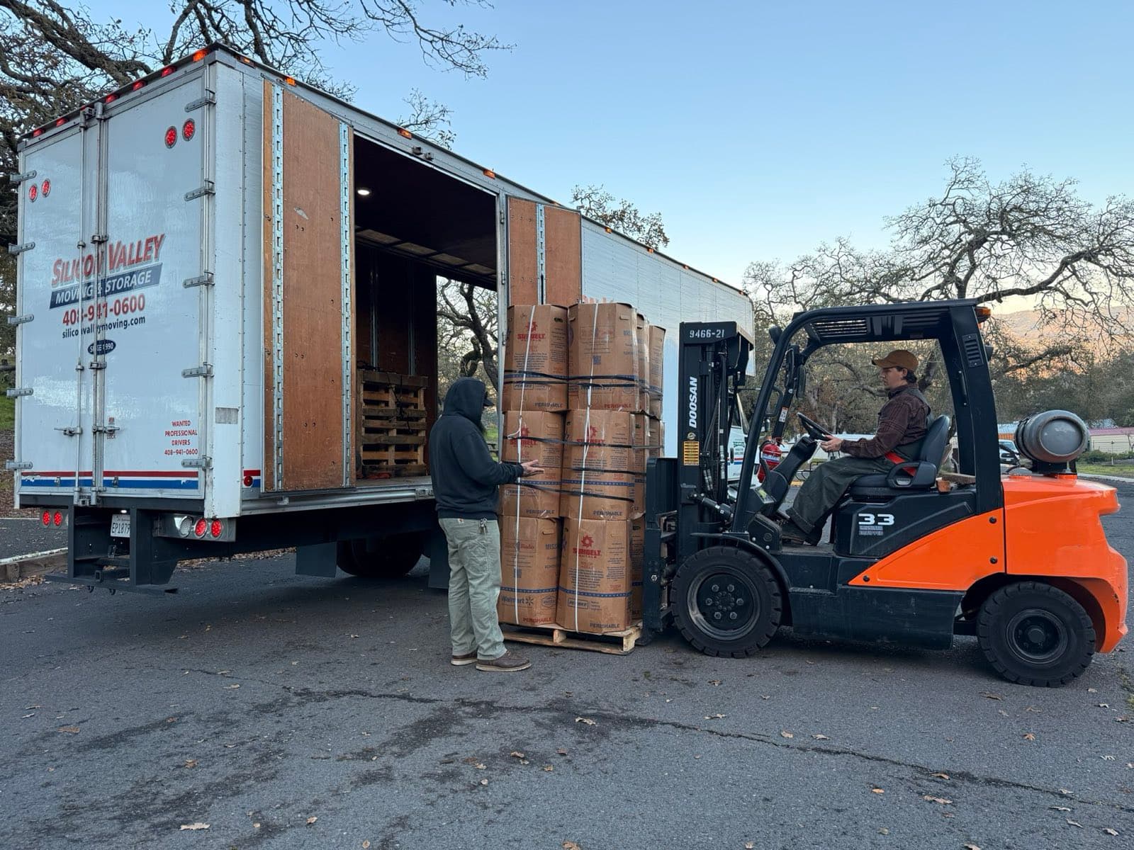 Silicon Valley Moving & Storage truck and forklift loading palletized commercial inventory during a Bay Area office decommissioning project
